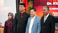 Dr. Kurnia Saleh berfoto bersama ayah dan ibunya usai meraih gelar Doktor Ilmu Hukum dalam sidang promosi doktor di Palembang.