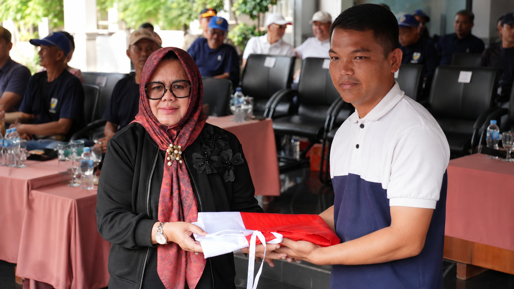 PLT Bupati Muara Enim Hj Sumarni menerima Bendera Merah Putih secara simbolis saat pelepasan Lomba Gerak Jalan Indah
